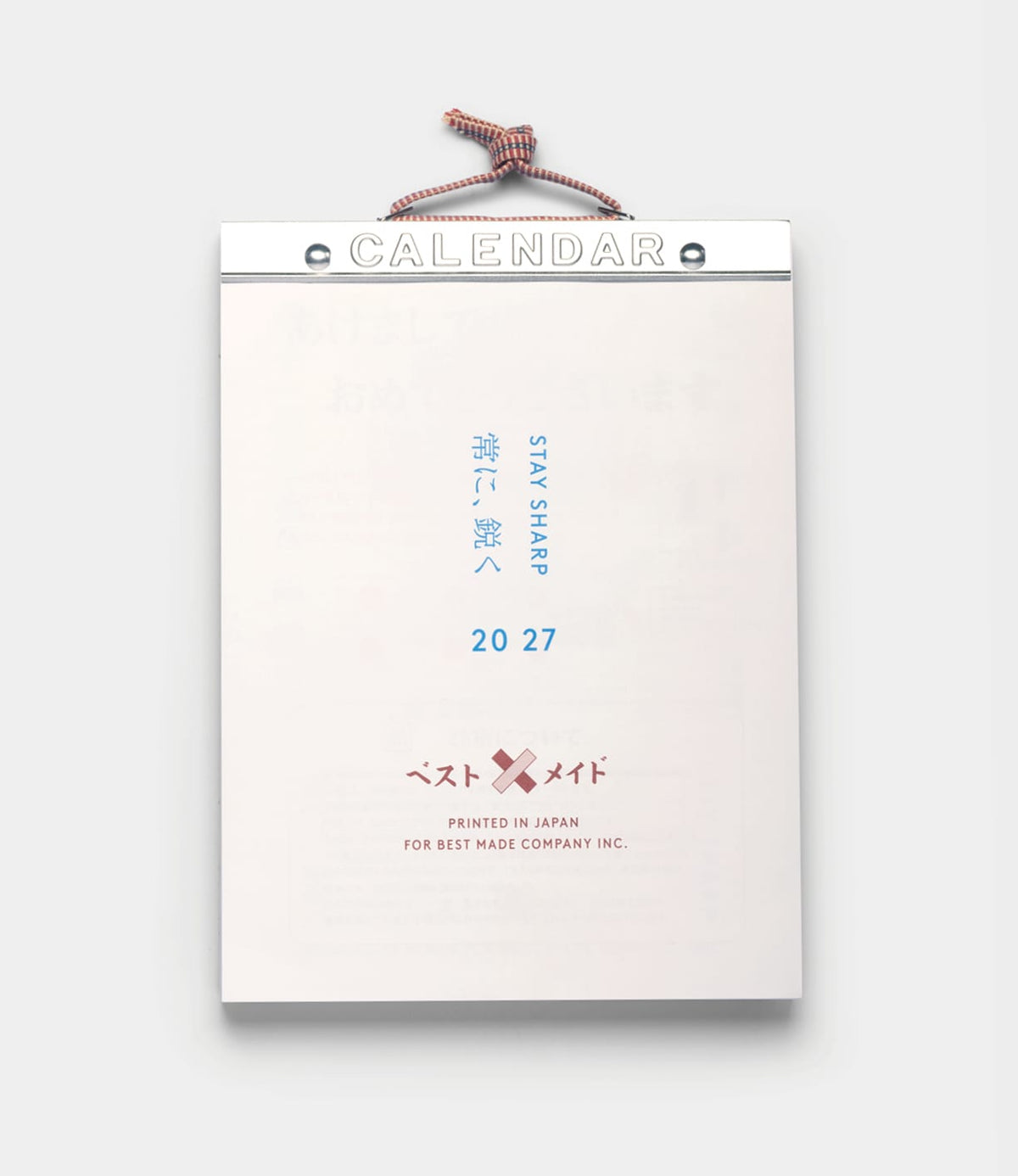 A hanging Himekuri Calendar 2027 traditional Japanese tear-off calendar with CALENDAR at the top, featuring the text STAY SHARP, 20 27, and a logo with two crossed bandages.