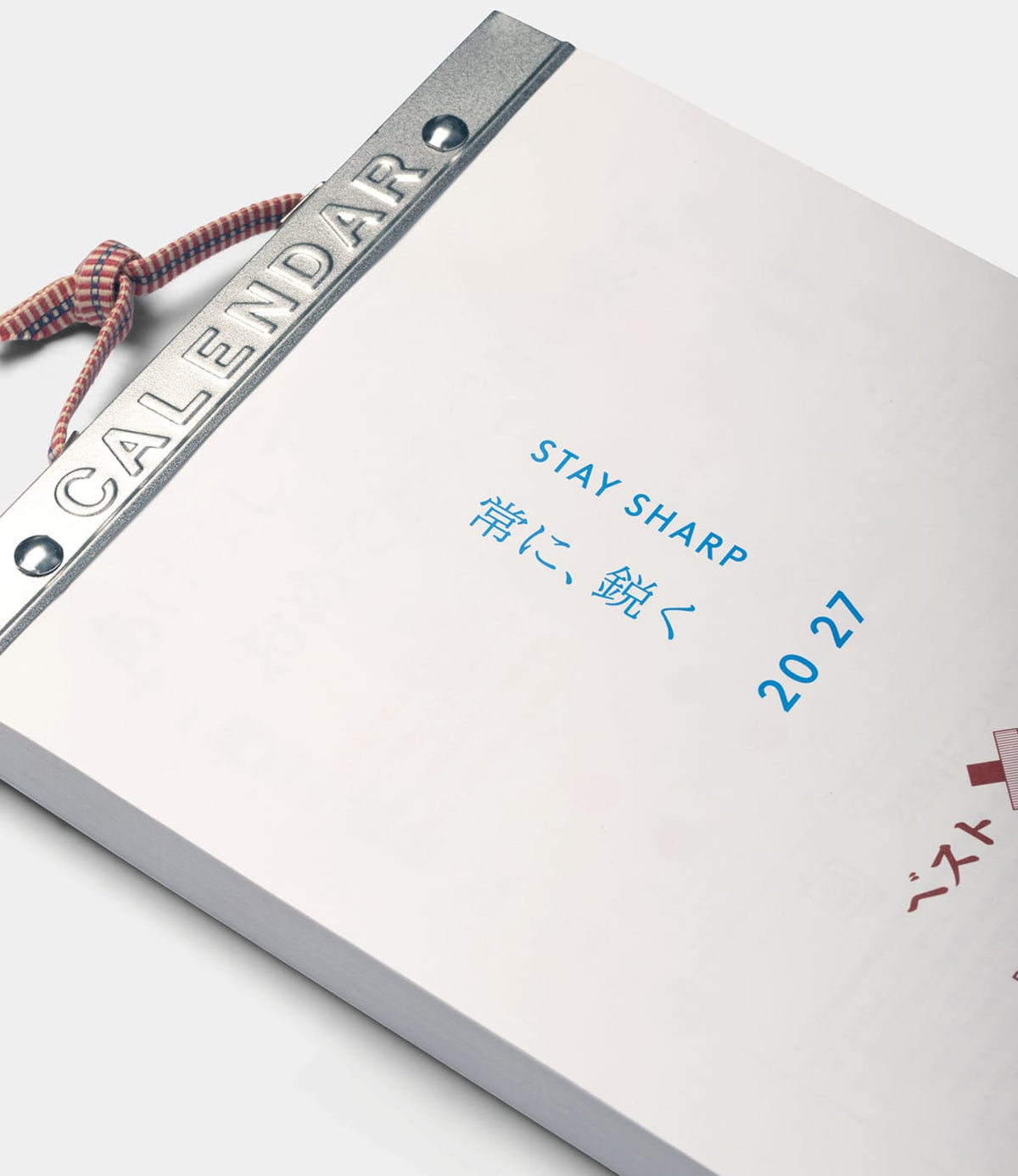 A Best Made Co. Himekuri Calendar 2027 traditional Japanese tear-off wall calendar with a metal header that reads CALENDAR, featuring the text STAY SHARP, 常に、鋭く, and 20 27 printed in blue on a white page.