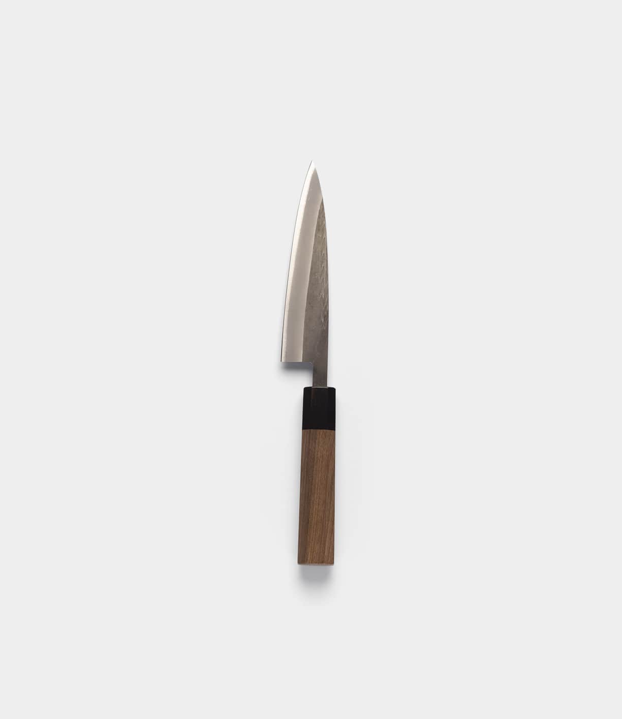 The Best Made Co. Aogami Petty is a small kitchen knife featuring a gleaming Aogami blue steel blade and a rectangular Shou Sugi Ban handle, shown against a simple light gray background—an elegant showcase of Japanese Chef Knives craftsmanship.