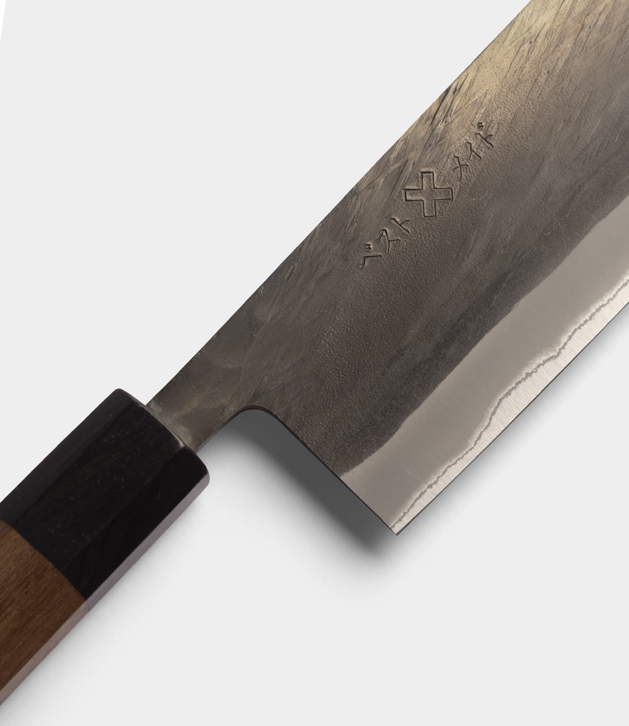 Close-up of the Best Made Co. Aogami Nakiri Knife, featuring a wooden handle and a forged Blue Paper Steel No. 2 blade engraved with Japanese characters and symbols.
