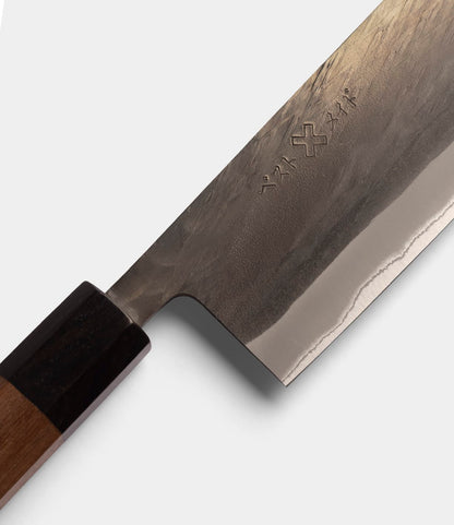 Close-up of the Best Made Co. Aogami Nakiri Knife, featuring a wooden handle and a forged Blue Paper Steel No. 2 blade engraved with Japanese characters and symbols.