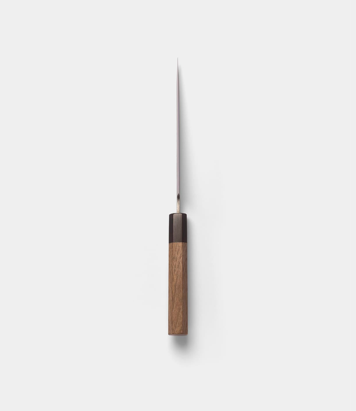 A Best Made Co. Aogami Petty Knife with a wooden handle is displayed vertically from above, its san-mai blade pointing upward and centered against a plain white background.
