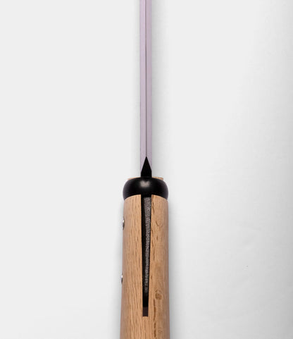 Close-up of the top view of a Best Made Co. Sayanata Hatchet handle made of wood with a visible slot, metal rivets, and a thin Nippon carbon steel blade extending upward against a plain white background.