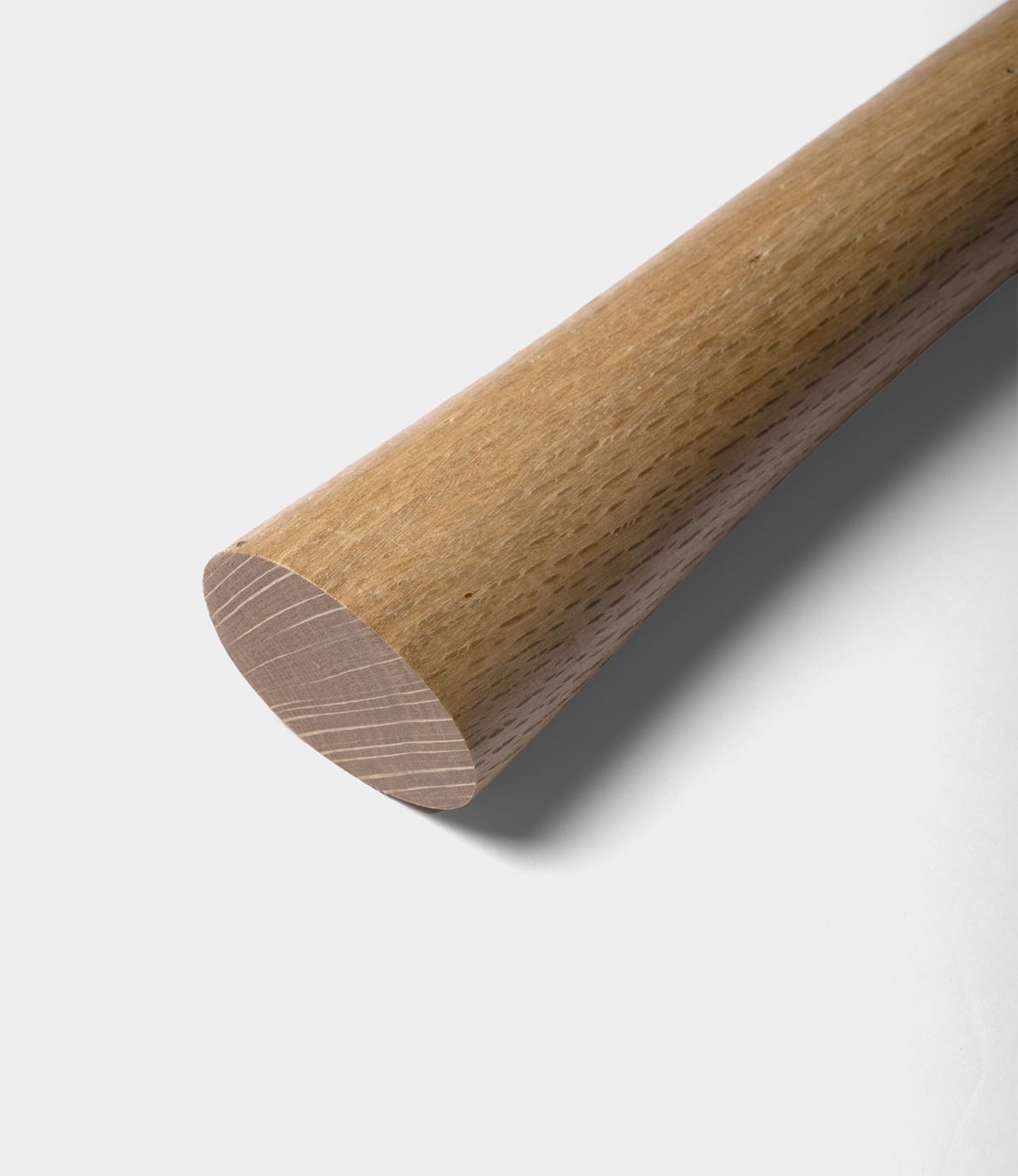 A close-up of the smoothly finished wooden handle of the Best Made Co. Azuma Hatchet, featuring a distinctive diagonal cut at the end and showcasing its fine wood grain against a plain white background.