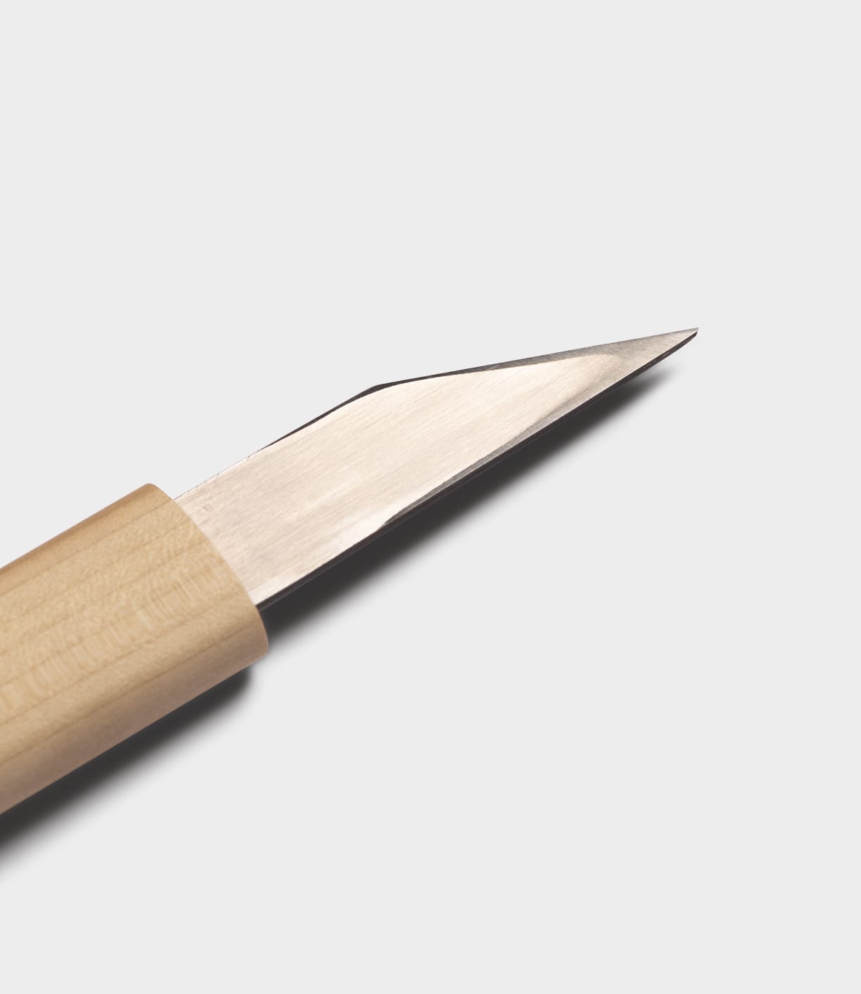 A close-up of the Best Made Co. Kiridashi Knife features its sharp, single beveled edge and light wooden handle, set against a plain white background.