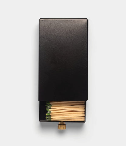 Best Made Co. Sliding Match Safe Black, partially open to reveal green-tipped strike-anywhere matches inside the black metal case.
