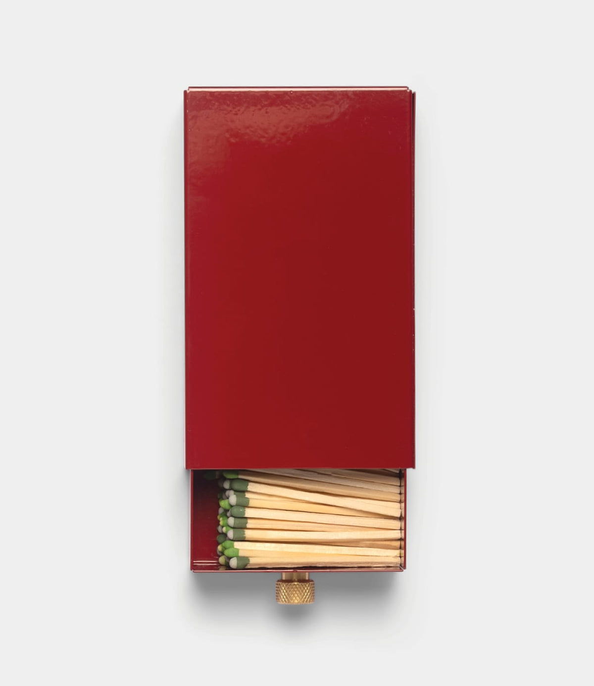 A Sliding Match Safe Red, partially opened to reveal a collection of wooden matches with green tips.