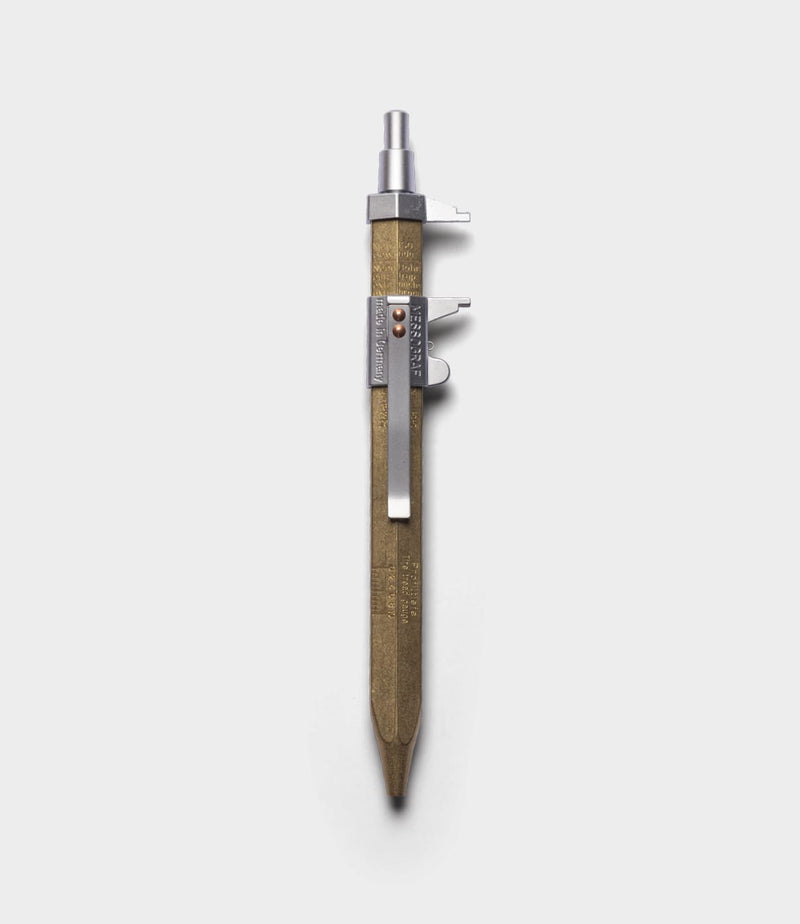 The Best Made Co. Brass Messograf Pen with a hexagonal brass body, metal clip, and exposed push button stands vertically on a plain white background.