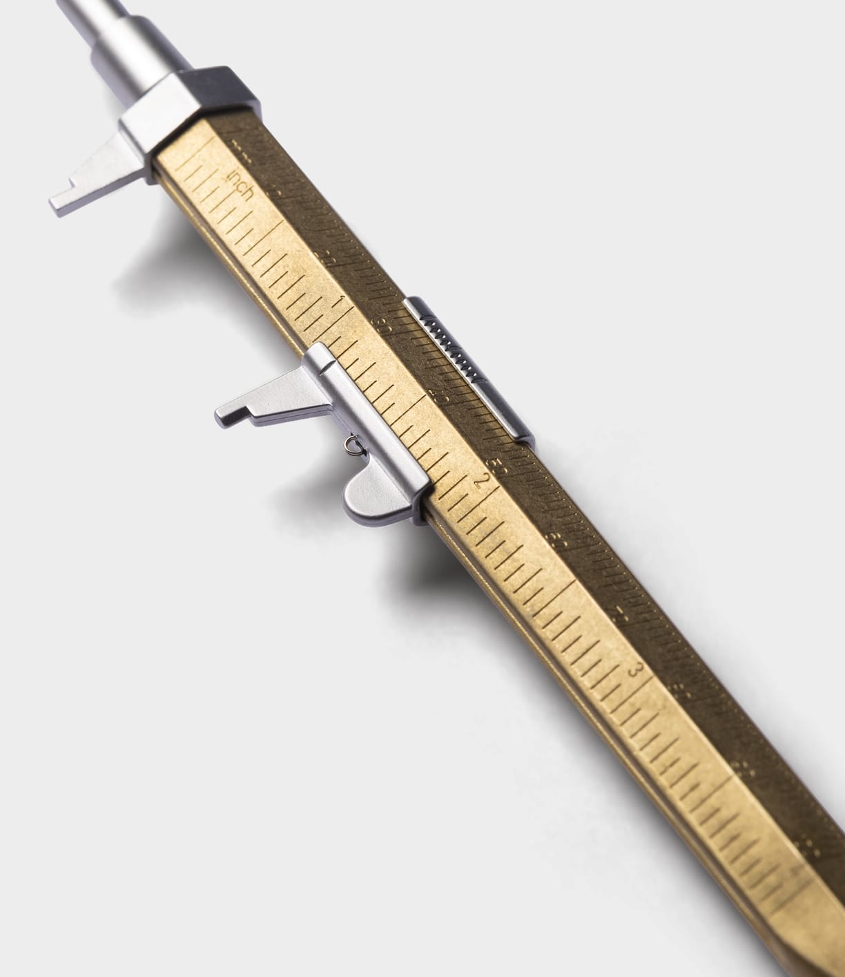 Close-up of the Best Made Co. Brass Messograf Pen, featuring engraved measurement markings and a sliding scale, shown beside a brass utility pen compatible with G2 refills on a white background.
