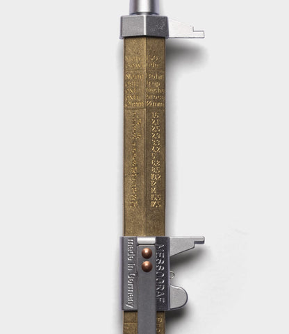 A close-up of a vintage-style Brass Messograf Pen by Best Made Co., featuring engraved measurement markings and a metal lock, set alongside a classic pen on a white background.