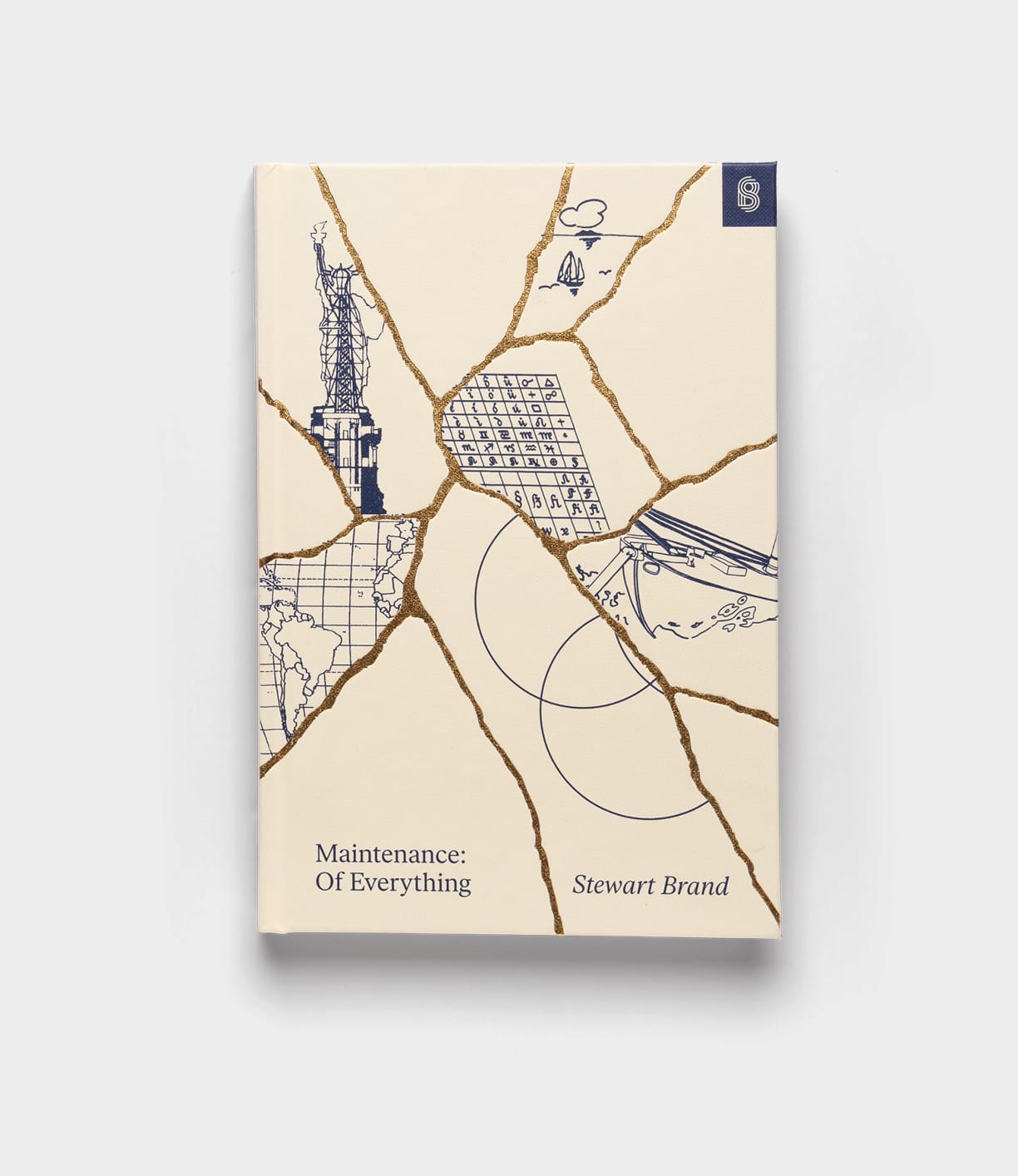 The Best Made Co. book "Maintenance of Everything" features a cream cover accented with gold cracks, illustrated Statue of Liberty fragments, a shipping container, map details, and waves on a plain background.