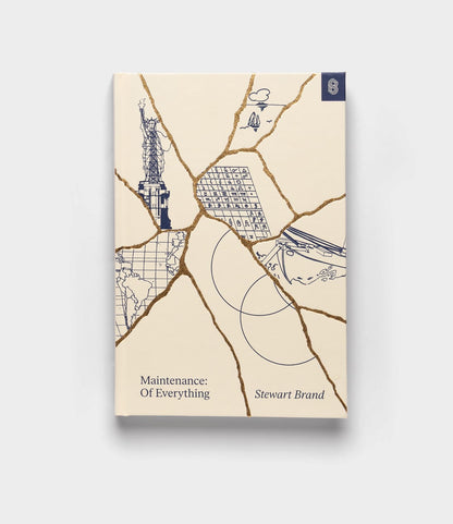 The Best Made Co. book "Maintenance of Everything" features a cream cover accented with gold cracks, illustrated Statue of Liberty fragments, a shipping container, map details, and waves on a plain background.