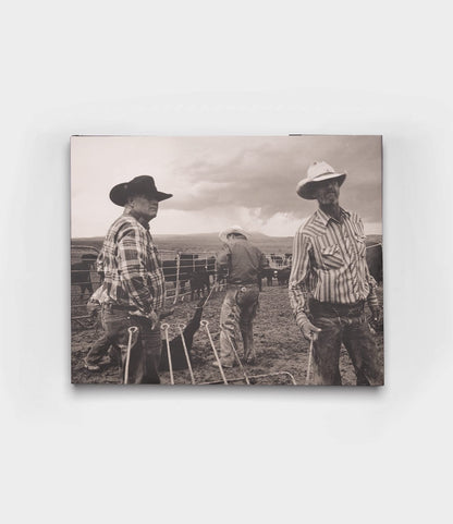 Three cowboys in hats and plaid shirts stand on a ranch with cattle behind them in this black-and-white image from Open Range by Best Made Co., evoking the timeless, vintage style of classic photography books.