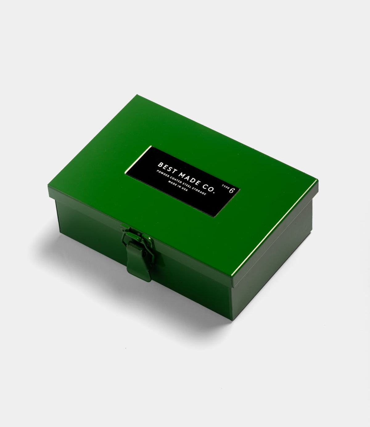 A closed Type 6 Strongbox Green by Best Made Co., featuring a black BEST MADE CO. label, secure latch, and sturdy green metal design, photographed on a plain white background.