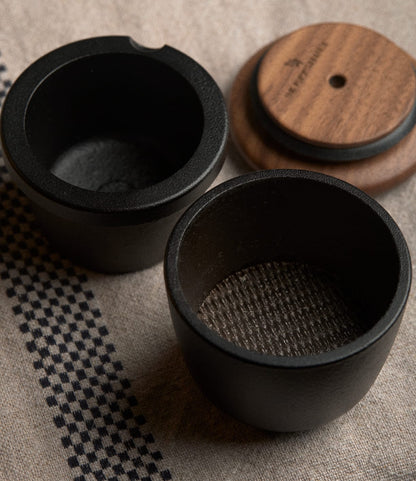 Two Best Made Co. Cast Iron Grinders with matching walnut lids resting on a woven fabric surface.