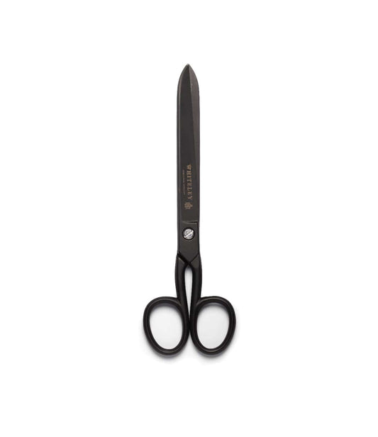A pair of Best Made Co. Ten-Inch Paper Scissors, featuring large black ergonomic handles and sharp hot-forged carbon steel blades, stand vertically on a plain white background.