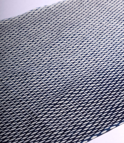The Ami Net Tenugui by Best Made Co. is a hand-dyed Japanese cloth with a repeated diagonal navy and white elongated diamond pattern, showcasing wabi-sabi beauty when laid flat on a white surface.