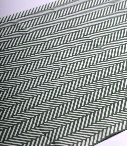 A close-up of the Sugi-Aya Tenugui by Best Made Co., showcasing hand-dyed Japanese fabric with green and white herringbone stripes in a wabi-sabi zigzag pattern.