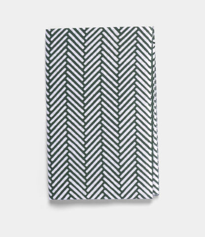 The Sugi-Aya Tenugui by Best Made Co. is a folded, hand-dyed Japanese cloth with a white background and dark green herringbone pattern, crafted using the traditional chusen technique.