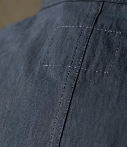 Close-up of the Possibilities Jacket Navy by Best Made Co. shows dark blue ripstop fabric with visible stitching, a rectangular patch, and vertical seam, highlighting the quality craftsmanship of this lightweight outerwear.