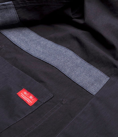 Close-up of the inside of the Best Made Co. Possibilities Jacket Navy, featuring herringbone-patterned trim and a red label with white text stitched onto an interior pocket.