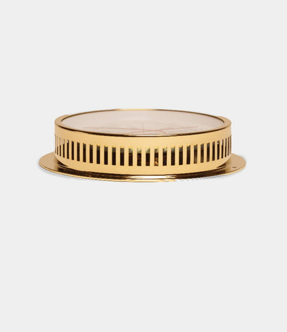 The Best Made Co. Weather Station features a round, gold-colored brass case with vertical slits on its sides, shown from the side against a white background. Its design is reminiscent of a decorative tray or instrument base.