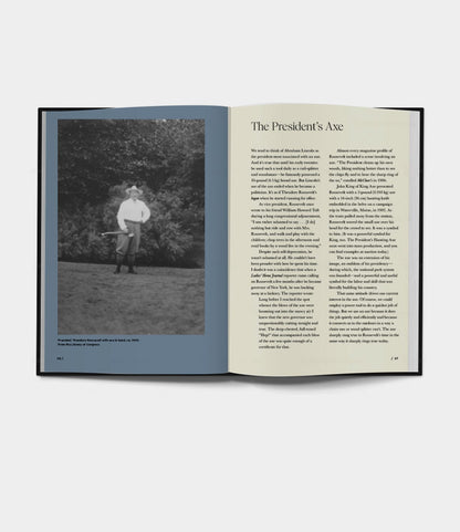 An open Buchanan-Smith’s Axe Handbook (signed) from Best Made Co. shows a black-and-white photo of someone holding an axe on the left and an article, “The President’s Axe” by founder Peter Buchanan-Smith, on the right page.