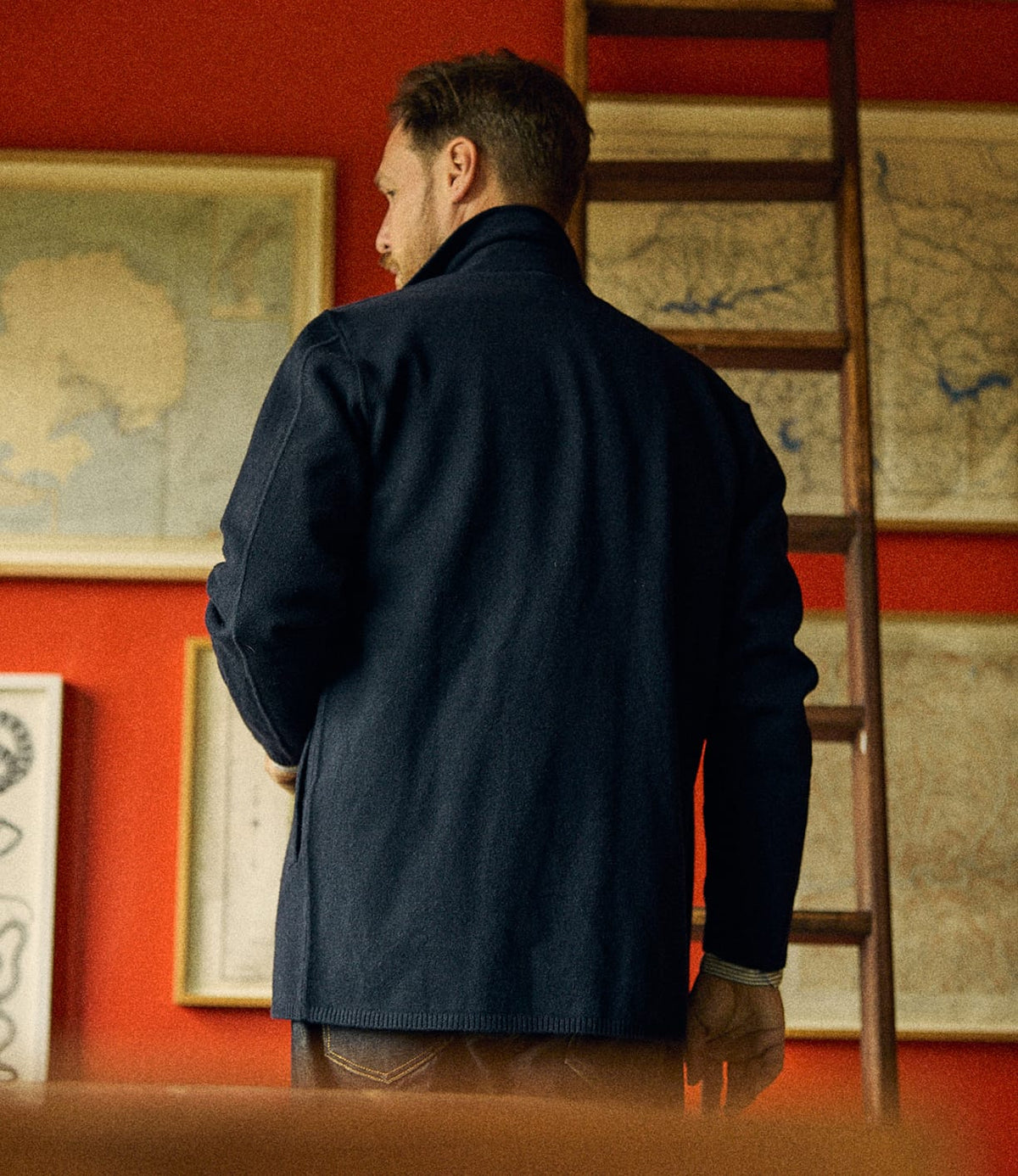 A man seen from behind wearing a dark blue Knit Lambswool CPO overshirt with a folded collar.
