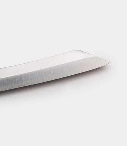 Close-up view of the tip of a shiny, metallic Max Brass Higo Knife blade by Best Made Co. on a plain white background.
