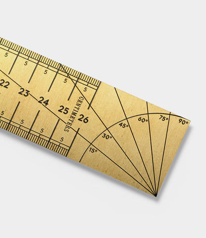 A close-up of the Best Made Co. Measure Twice 12 inch Solid Brass Ruler shows black engraved centimeter markings and a 0°–90° protractor section, precision-crafted in the USA, set against a white background.
