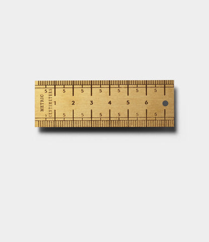 The Best Made Co. Measure Twice 3 inch Solid Brass Ruler lies horizontally on a white background, displaying measurements from 0 to 3 inches and casting a slight shadow to the lower right.