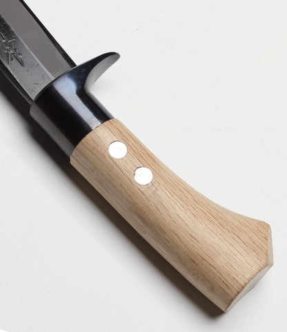 A close-up of the Hotta San Hunting Knife by Best Made Co. shows its light wood handle with two metal rivets and a black metal blade, resting on a white surface.