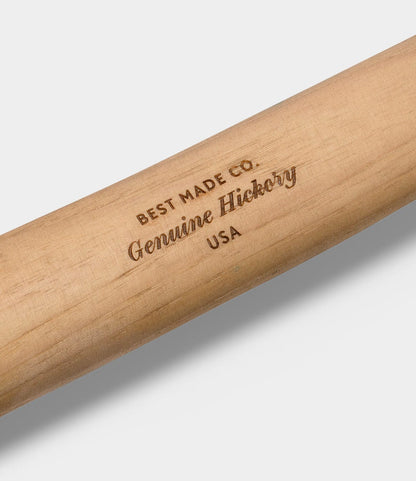A close-up of the Old Gold No. 1 axe by Best Made Co., showing its wooden handle engraved with BEST MADE CO. Genuine Hickory USA.