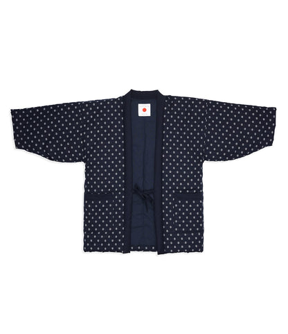The Best Made Co. Quilted Hanten Jacket is a traditional indigo blue Japanese jacket with a geometric dot pattern, front ties, two pockets, and an inside collar label featuring a red circle.