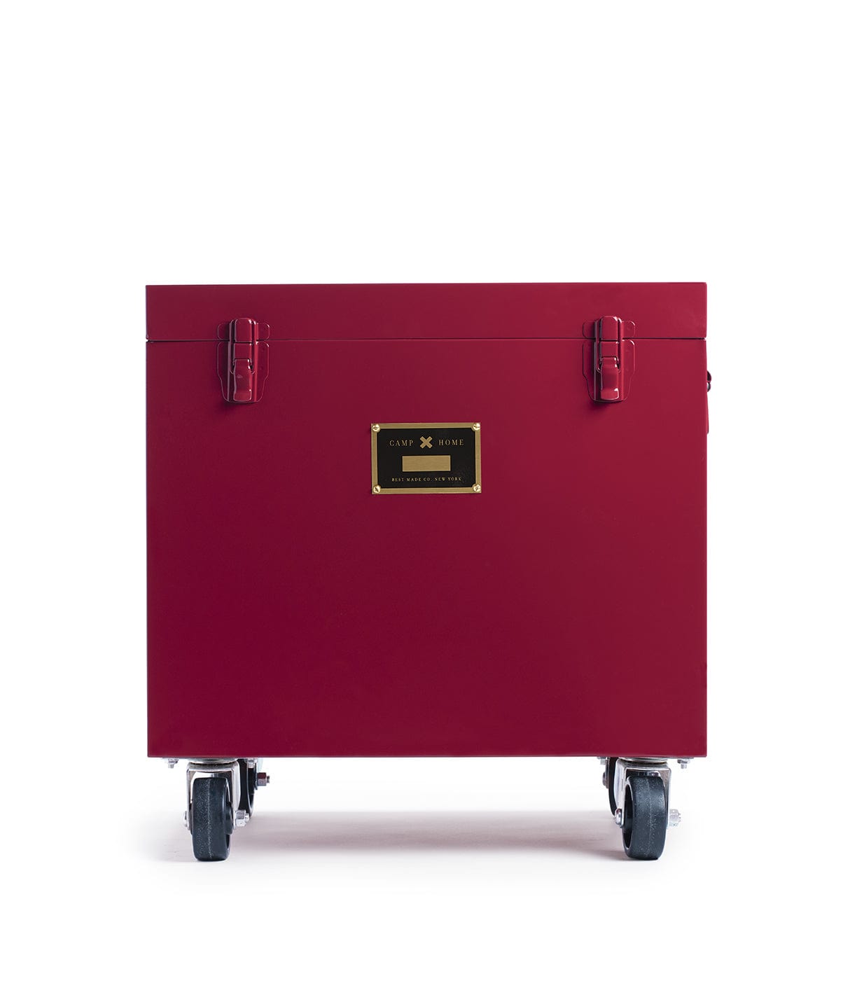 A red, rectangular Rolling Footlocker by Best Made Company Archive, constructed from 22-gauge steel with metal latches and a gold label, is set on four caster wheels and photographed against a plain white background.