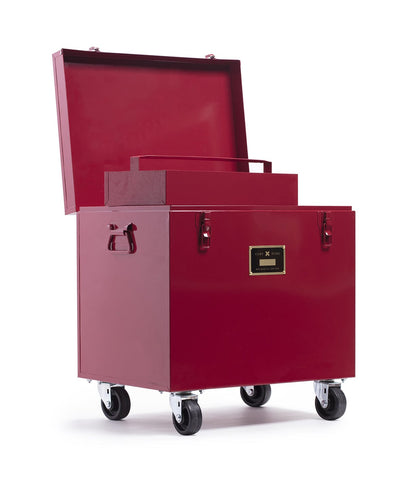 A large red metal Rolling Footlocker by Best Made Company Archive on wheels, featuring a hinged lid that opens to reveal a removable tray inside. Crafted from heavy-duty 22-gauge steel, it includes side handles and a front label plate for added convenience.